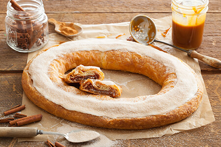 Churro Kringle topped with icing and cinnamon sugar