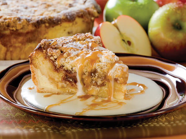 Danish Cinnamon Apple Bread Pudding served on a ceramic plate with cream