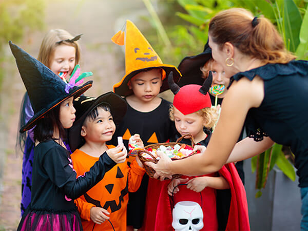 A group of young children in Halloween costumes trick or treating