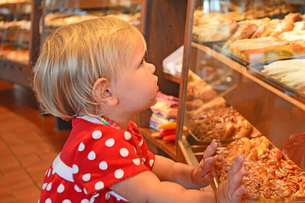 Baby girl admiring Danish pastries at a bakery