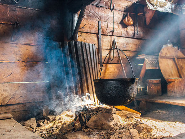 Cast iron cooking pot hanging over fire