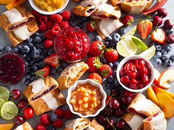 Charcuterie dessert board with Kringle, fruits, and jams