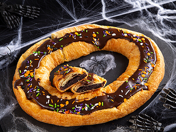 Wicked Good Kringle surrounded by fake spiders and spiderwebs