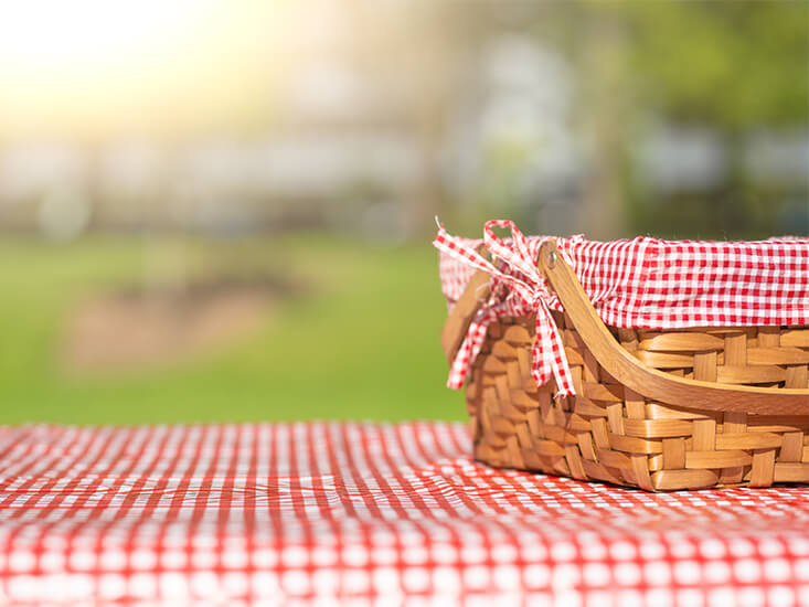 picnic basket and blanket in a grassy meadow