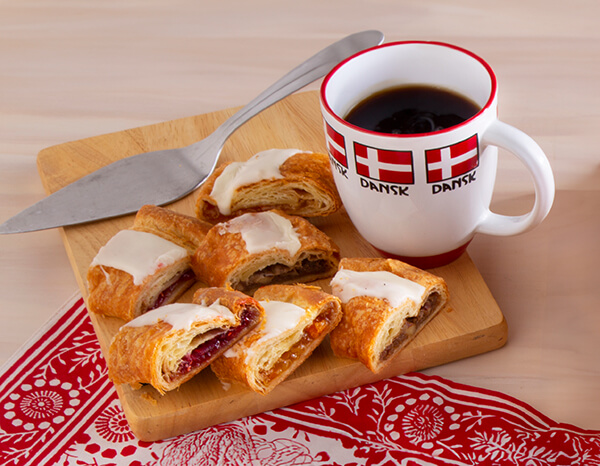 Kringle slices on a cutting board with a cup of Gokstad coffee