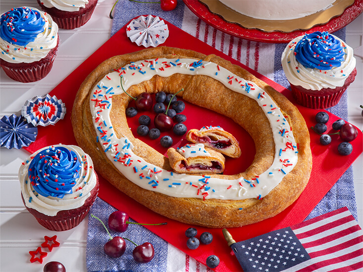 Red, White, and Blue Kringle and giant Stars and Sprinkles Cupcakes desserts served on a table